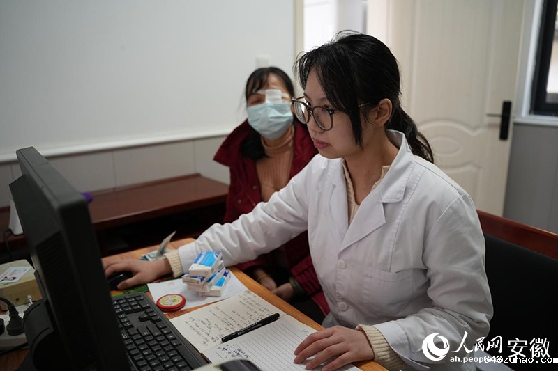 陈冉冉在卫生室里,给就诊村民开药。人民网记者 王锐摄